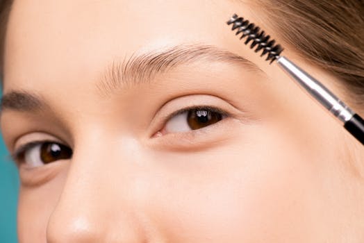 pexels-photo-3762668-3762668 Close-up of a woman applying makeup with an eyebrow brush, highlighting natural beauty.